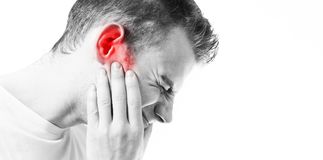 tinnitus-man-on-a-white-background-holding-a-sick-ear-suffering-from-pain-104505308